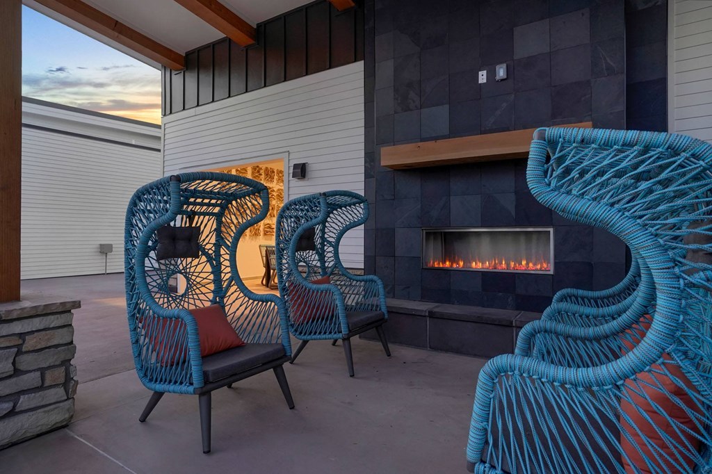 a group of blue chairs sitting in front of a fireplace