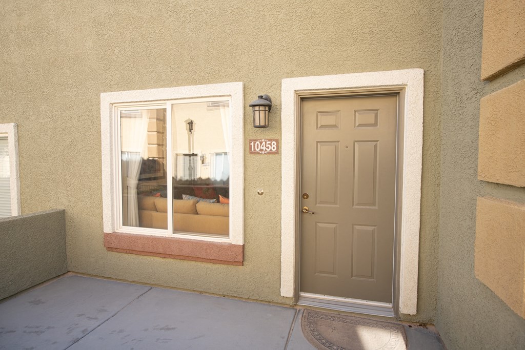 the front door of a building with a window and a brown door