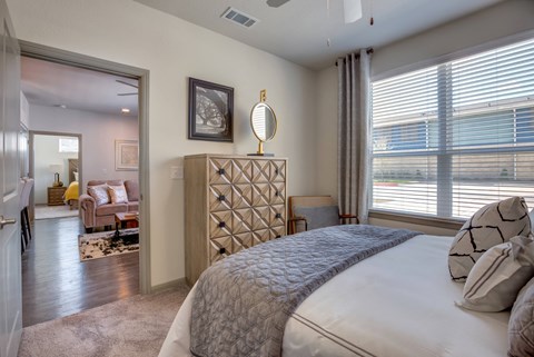 a bedroom with a large bed and a view of a living room