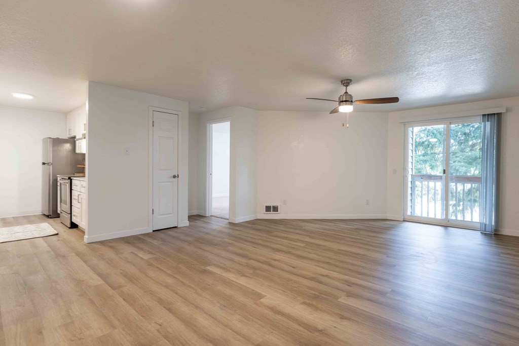 an empty living room with a ceiling fan
