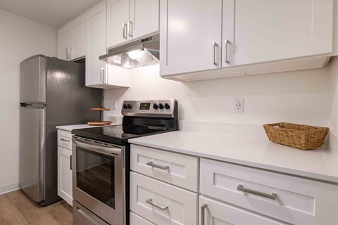 a white kitchen with stainless steel appliances and white cabinets
