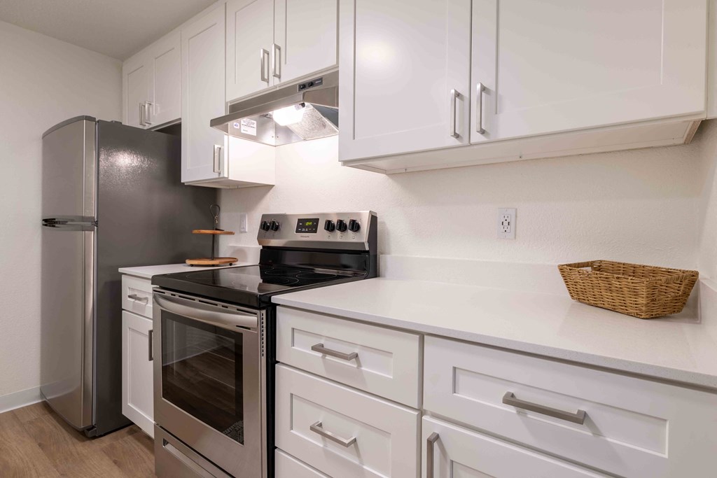 a kitchen with white cabinets and stainless steel appliances