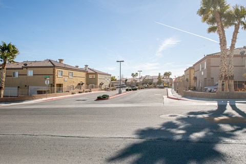 a city street with buildings and palm trees