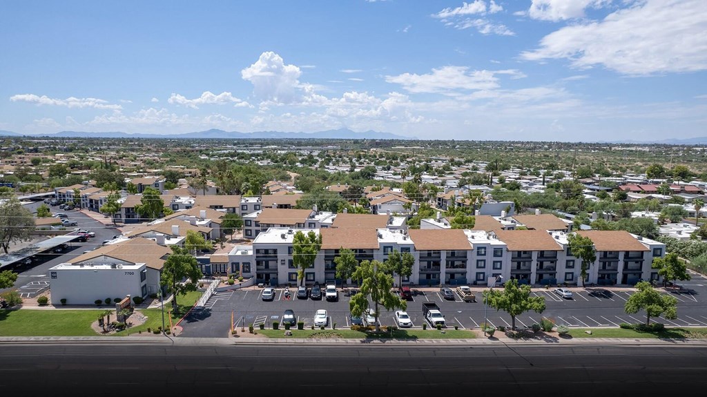 an aerial view of an apartment complex with cars parked in a parking lot