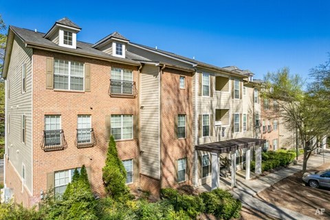 A multi-story apartment building with a mix of brick and siding exteriors.