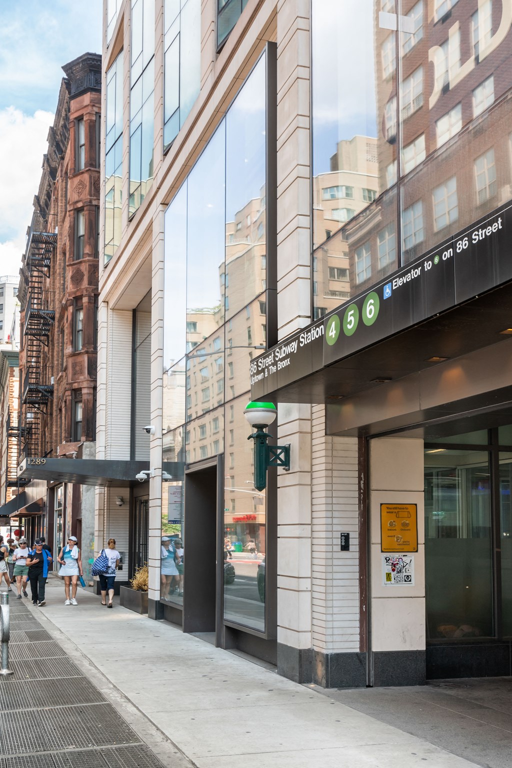 people walking down a street in front of a building