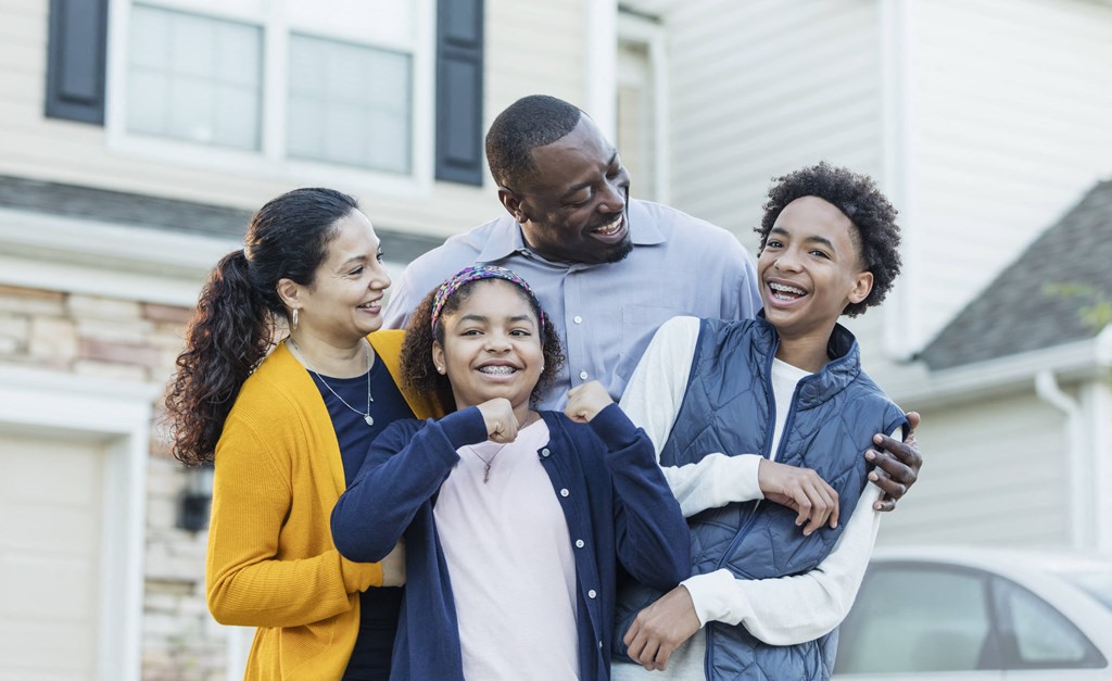 a family standing in front of a house