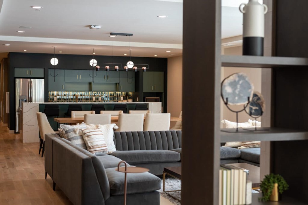 A grey sofa with a striped pillow is in the middle of a room.