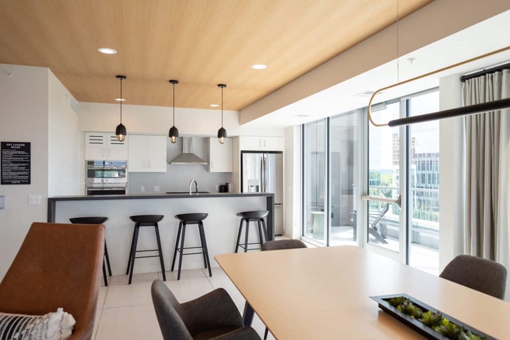 A modern kitchen with a bar area and a dining table.