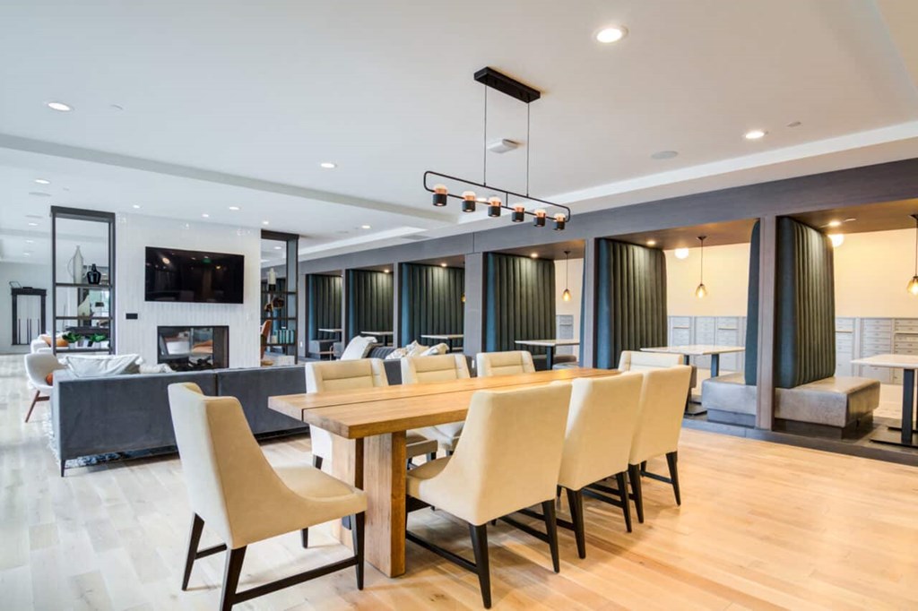 A modern dining room with a long table and chairs.