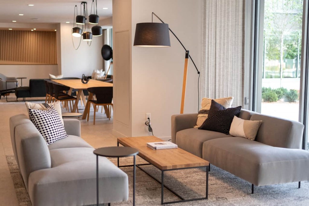 A modern living room with grey couches and a wooden coffee table.