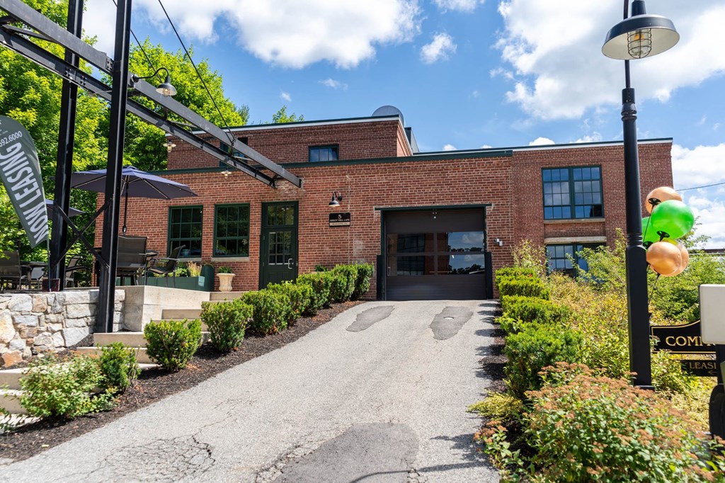 the front of a red brick building with a black garage door