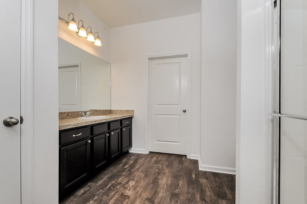 A kitchen with black cabinets and a white door.