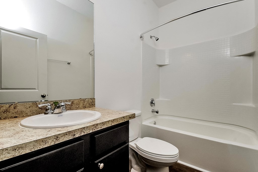 A white bathroom with a sink, toilet and bathtub.