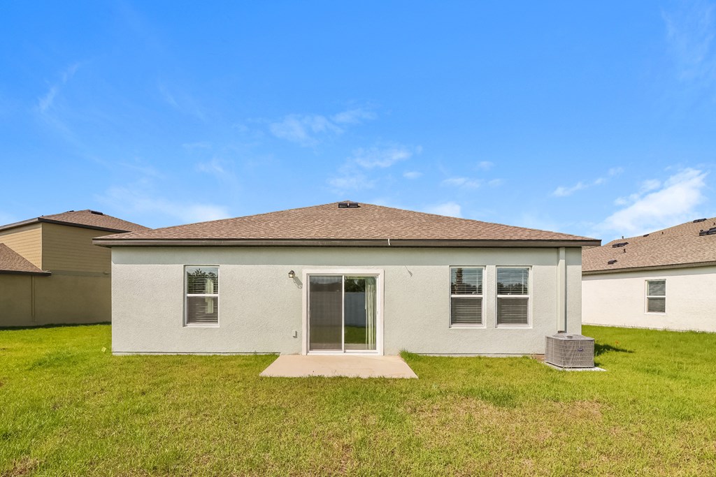 A white house with a brown roof and a grey door.