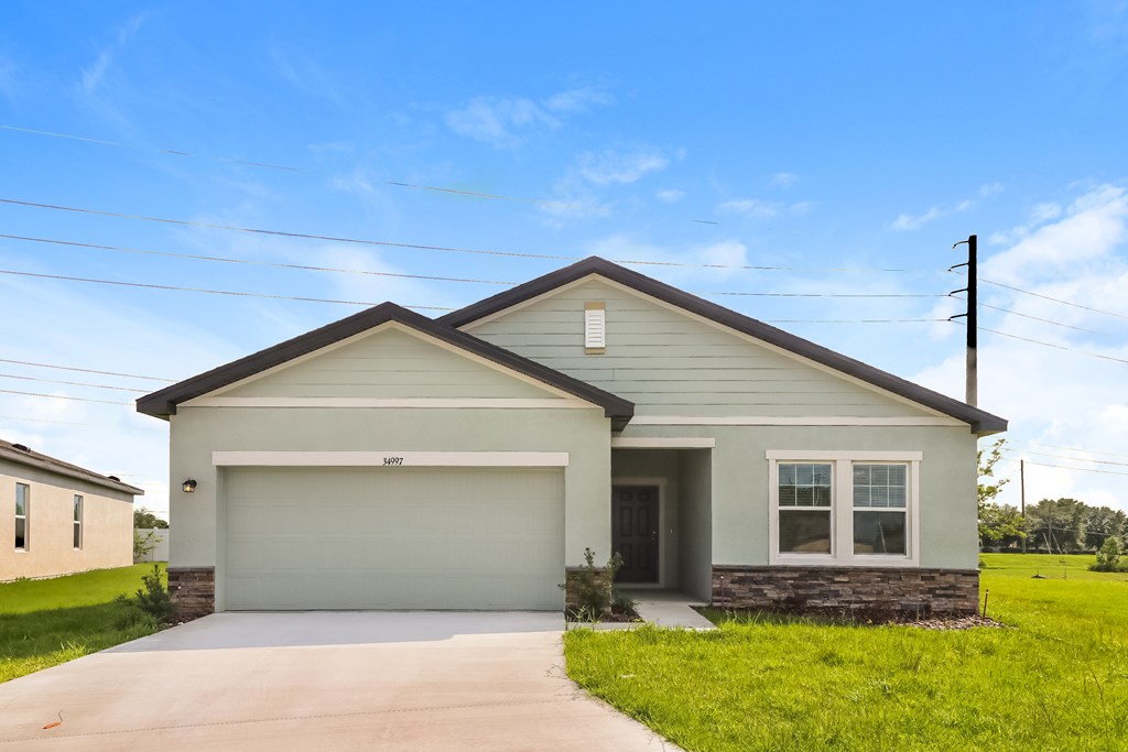 A house with a garage and a driveway in front.