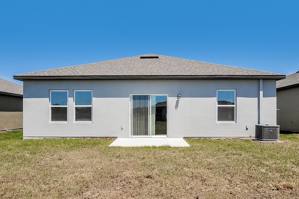 A house with a grey roof and white walls with a white door and windows.