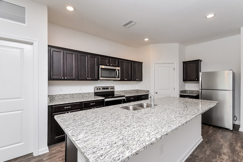 A kitchen with granite countertops and stainless steel appliances.