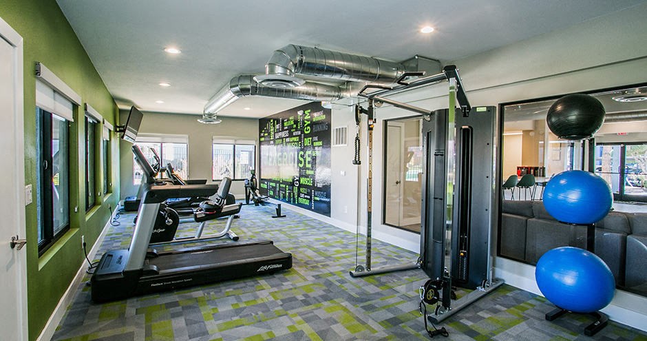 a home gym with a treadmill and weights on the floor