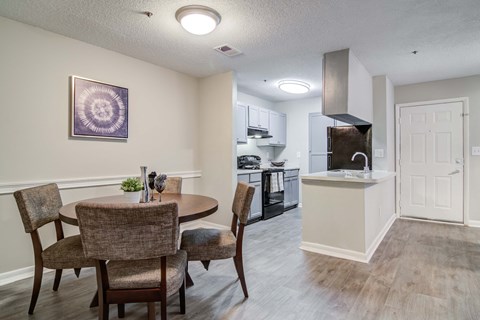 a dining room and kitchen with a table and chairs