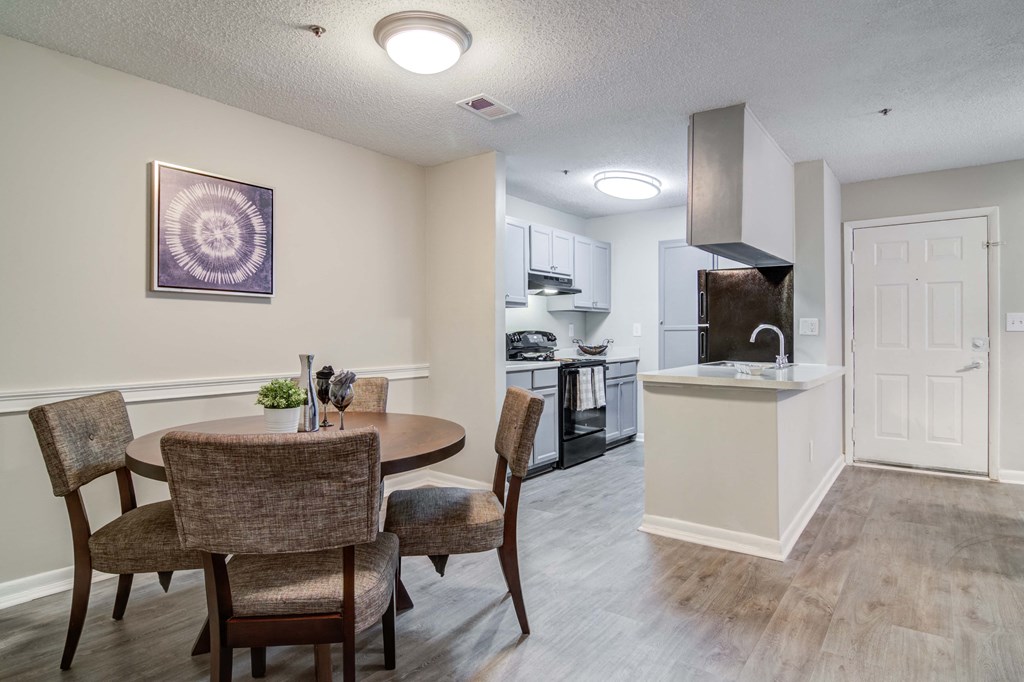 Flats at Riverview apartments in Duluth Georgia photo of a dining area with a table and chairs and a kitchen in the background