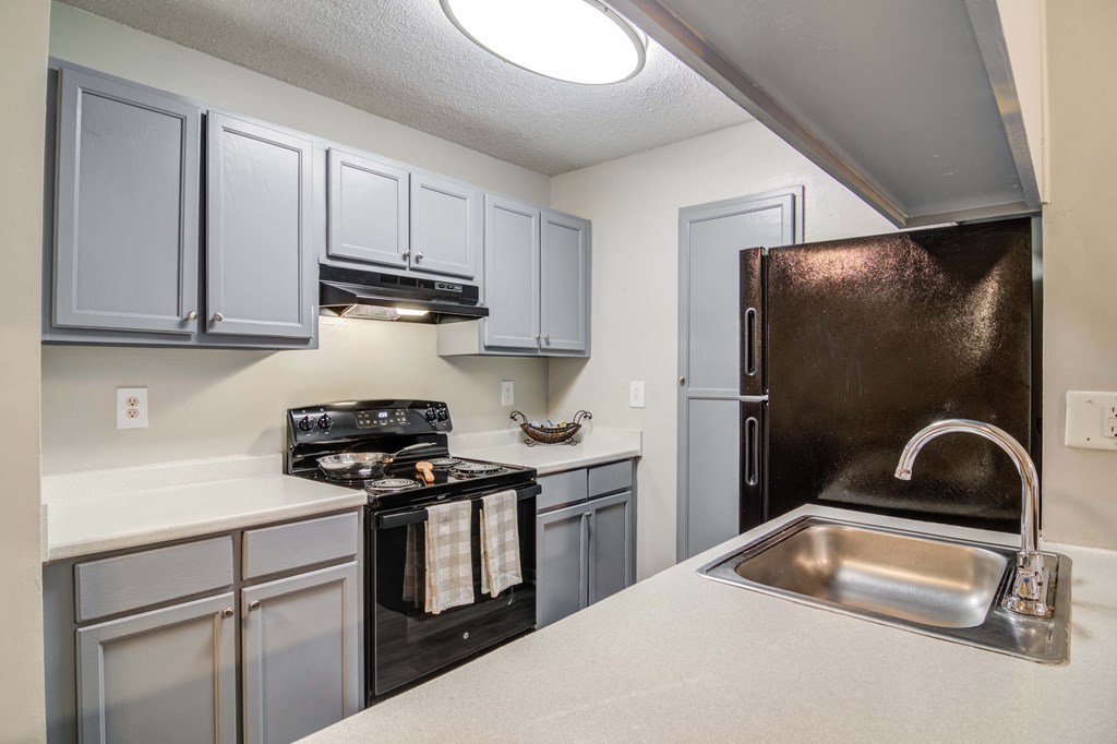 Modern kitchen with black appliances at Flats at Riverview apartments in Duluth, GA near Lawrenceville
