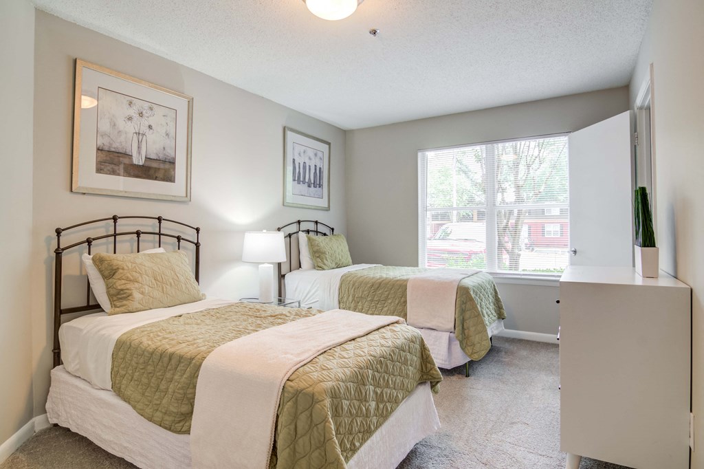 Well-lit bedroom featuring large windows at Flats at River View apartments in Duluth, GA, near Lawrenceville.