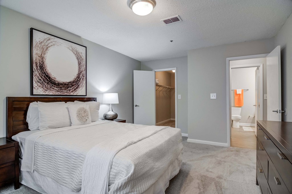 Flats at Riverview apartments in Duluth Georgia photo of a bedroom with a large bed and a dresser