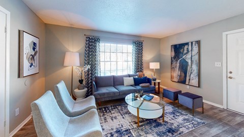 A living room with a grey sofa, a white chair, a coffee table and a rug.
