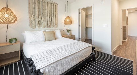A bedroom with a large bed and a lamp.