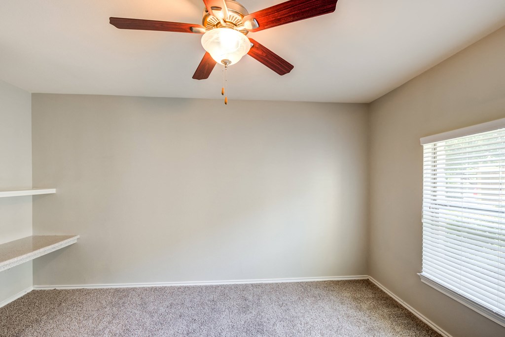 ceiling fan and bookshelf in bedroom
