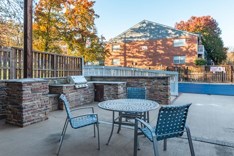a patio with a table and chairs in front of a pool