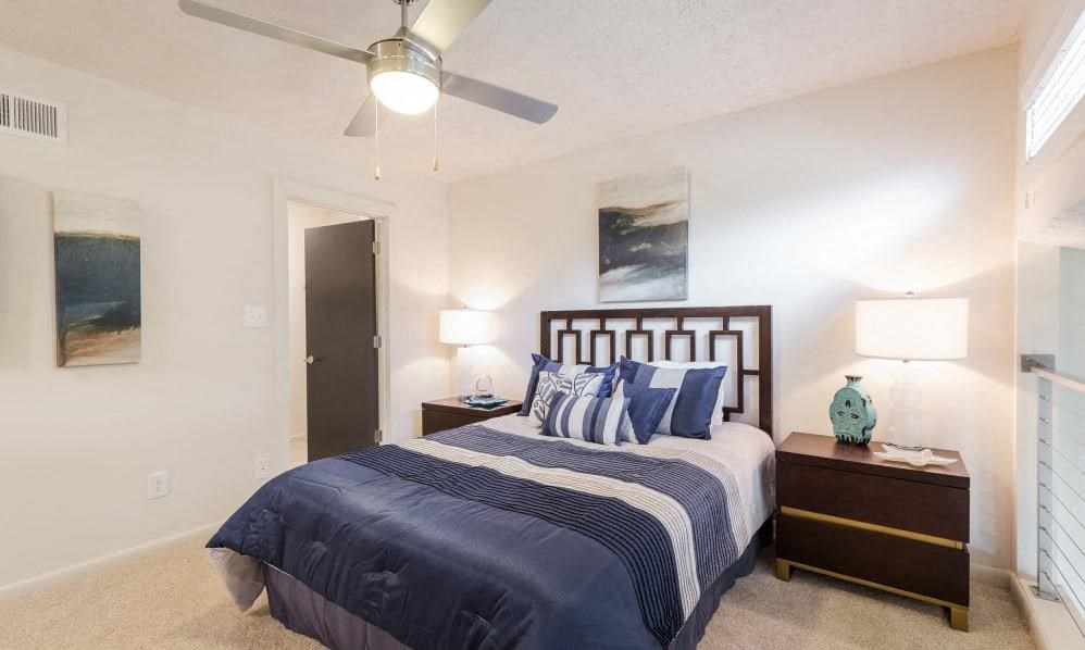 Townhouses for Rent in Smyrna GA - The Arlowe Townhomes - Bedroom with Beige Walls, Tan Wall-to-wall Carpet, Large Bed, and Ceiling Fan