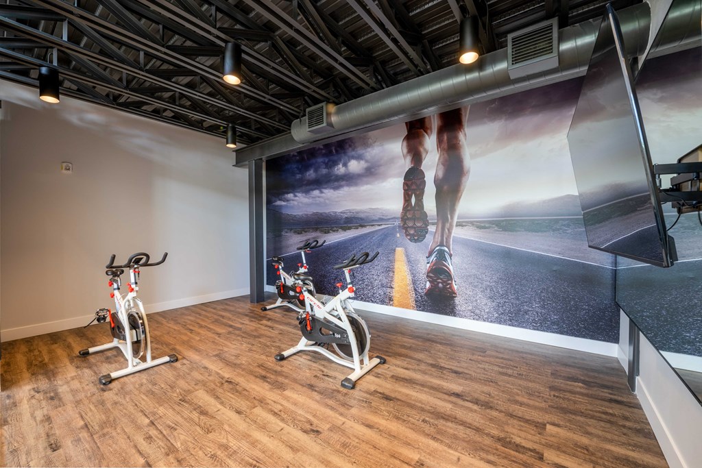 Gatehouse on the Green Apartments in Plantation, FL photo of a workout room with exercise bikes and a wall mural