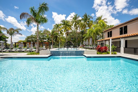 a swimming pool with palm trees in front of a house