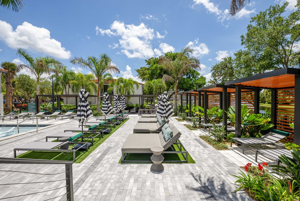 Gatehouse on the Green Apartments in Plantation, FL photo of a patio with lounge chairs and a pool