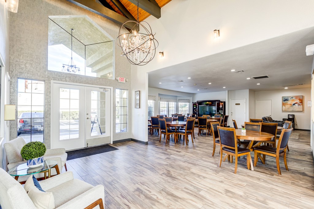 the living room and dining area of a house with large windows