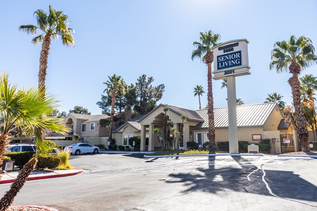 an empty parking lot in front of a hotel with palm trees