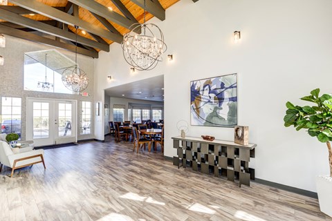 A large room with a wooden floor and a chandelier hanging from the ceiling.
