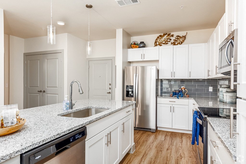 a kitchen with white cabinets and a stainless steel refrigerator