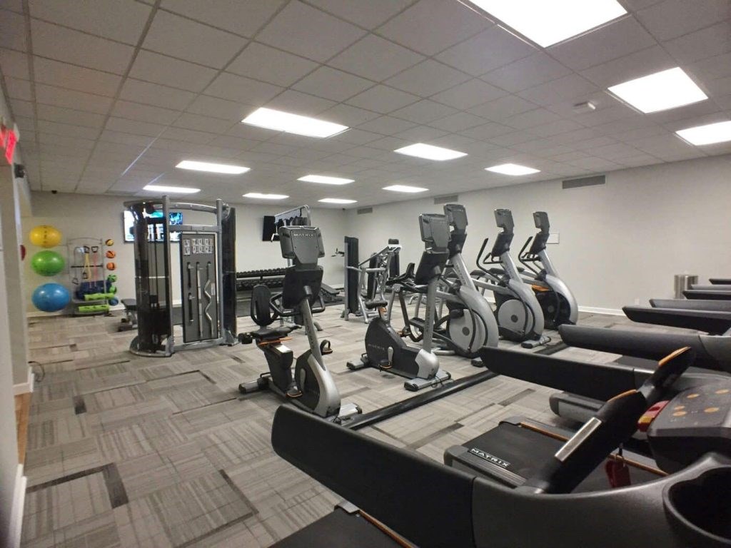 A gym with treadmills, elliptical machines, and other exercise equipment.