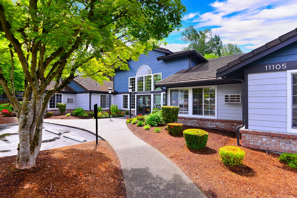 a sidewalk in front of a house with a tree