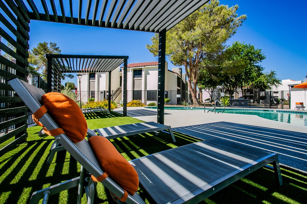 a pool with lounge chairs and a swimming pool