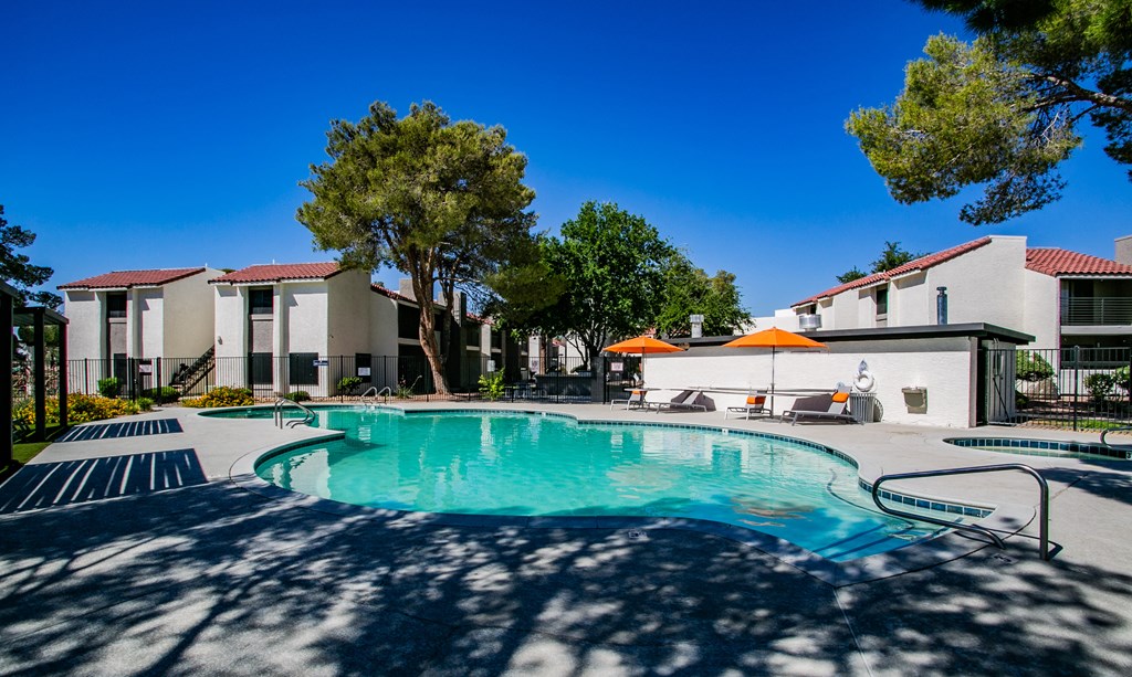 a swimming pool with trees and buildings in the background