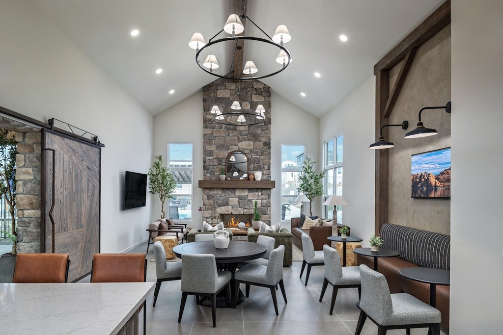 A modern dining room with a stone fireplace and a large table set for a meal.