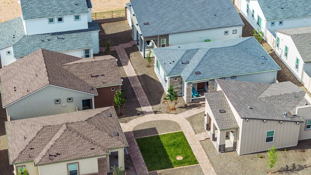 A bird's eye view of a neighborhood with houses and a green lawn.