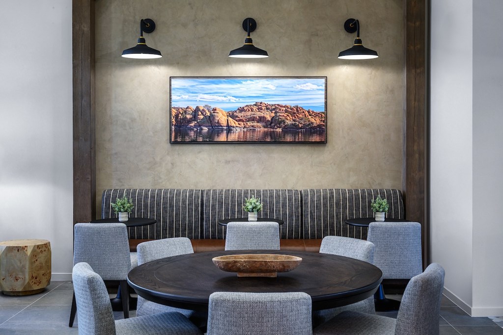 A dining room with a large table and chairs.