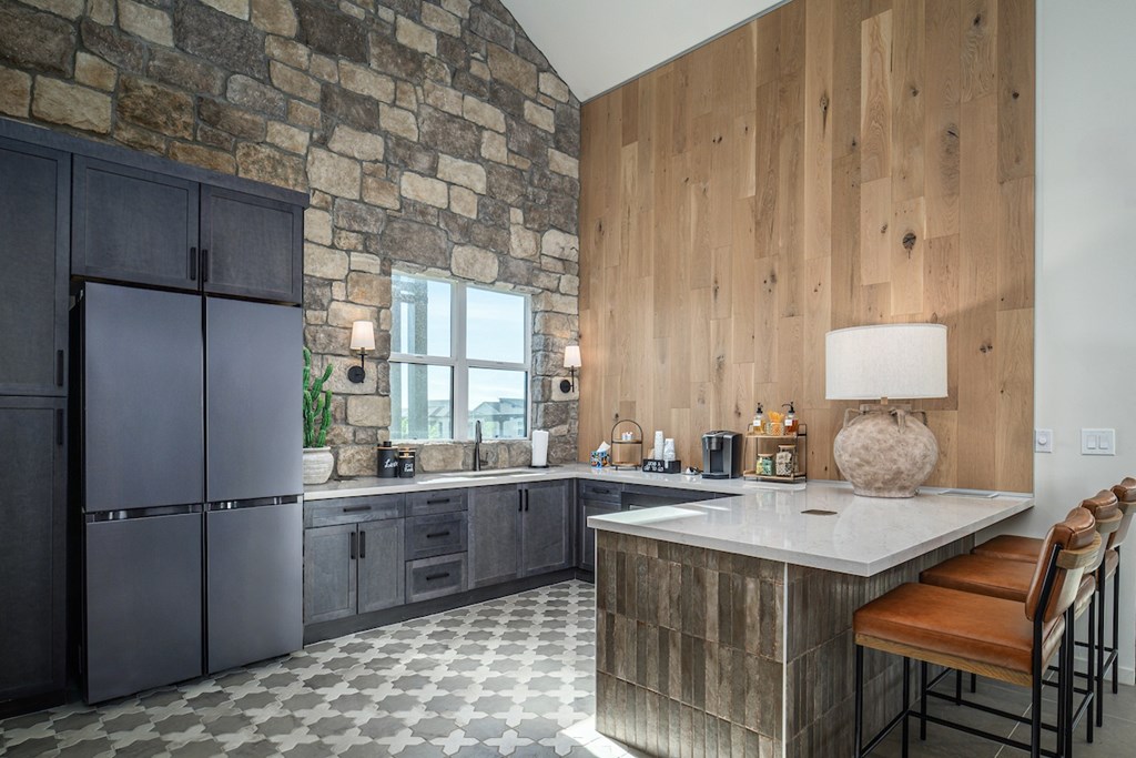 A kitchen with a stone wall and wooden paneling.