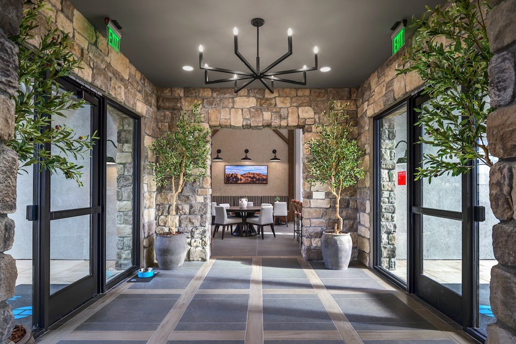 A stone wall with a TV and a table with chairs in front of it.
