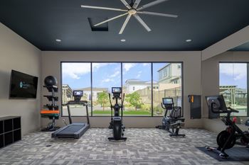 A gym with a treadmill, exercise bike, and other equipment.